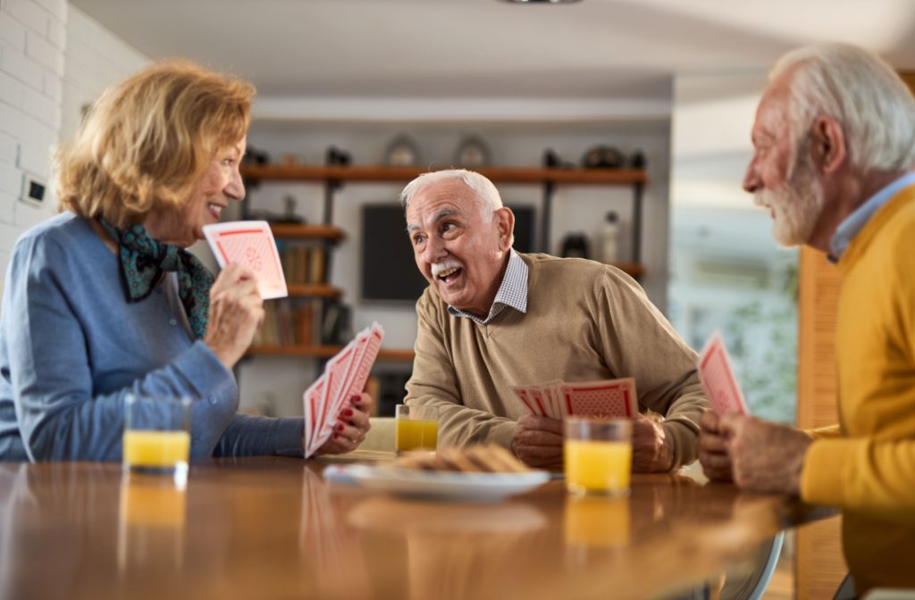 A group of residents in their independent living community are enjoying a game of cards.