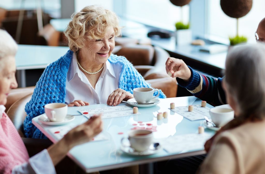 A group of seniors with smiling faces while playing bingo together.