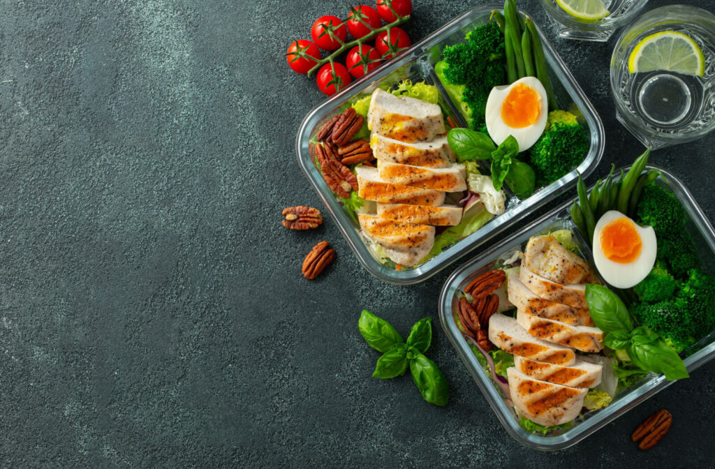 An overhead view of glass containers holding keto-friendly meals for a senior-safe diet.